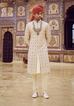 Elevate your look with this light beige raw silk sherwani, exquisitely embroidered with kasab and highlighted with dabka, beadwork, and crystals. Paired with a cotton silk kurta and churidar. Traditional Nehru Jacket With Pearl Embroidery For Eid, Long Sherwani In Raw Silk With Resham Embroidery, Traditional Cream Sherwani For Festive Occasions, Long Raw Silk Sherwani With Resham Embroidery, Bollywood Style Cream Bandhgala For Ceremonial Occasions, Bollywood Style Cream Bandhgala For Ceremonial Events, Bollywood Style Sherwani With Pearl Embroidery For Wedding, Ceremonial Cream Churidar With Resham Embroidery, Bollywood Cream Bandhgala For Ceremonial Occasions