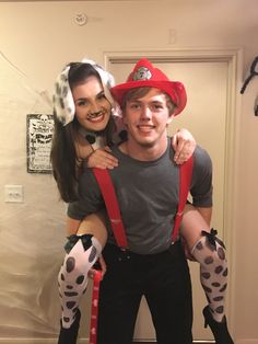 a man and woman dressed up as firemen posing for the camera with their arms around each other