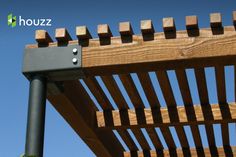 a close up of a wooden bench with blue sky in the background