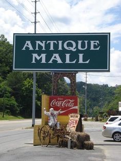 a sign that says antique mall with a horse and buggy in front of it