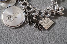 I am offering you this spectacular vintage sterling silver (stamped) mixed themed charm bracelet. This is a loaded charm bracelet having 15 unique mixed theme charms . It is on a classic wide multi leveled linked charm bracelet , the previous owner had several years of collecting here !! There are several that have enameling. It measures app. 7.25 inches long , and is app. 1.5 inches at it widest dangle point. It weighs app. 43 grams. This was a wonderful estate find from here in upstate new Yor Silver Engraved Charms For Collectors, Vintage Silver Charm Bracelet For Wedding, Collectible Silver Engraved Charms, Silver Charms Jewelry Souvenir, Nickel-free Silver Charm Bracelet Collectible, Nickel-free Silver Charm Bracelet For Collectors, Silver Charm Bracelet With Hallmark As A Gift, Nickel-free Silver Charms Souvenir, Nickel-free Silver Charms For Souvenir