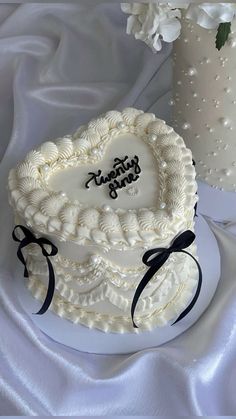 a heart shaped cake sitting on top of a table next to a vase filled with flowers