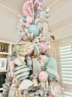 a christmas tree decorated with pastel colors and ribbons