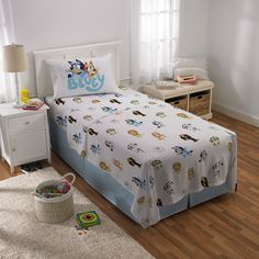 a child's bed with toy cars on it in a white and blue bedroom