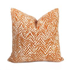 an orange and white pillow on a white background