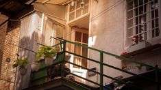 an apartment building with plants on the balconies and potted plants in pots