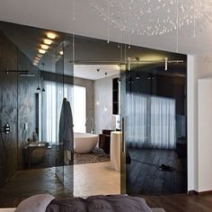 a bedroom with a large bed and glass walls