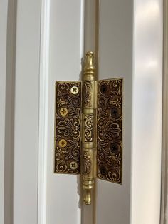 an ornate door handle on a white door