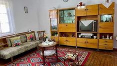 a living room filled with furniture and a flat screen tv on top of a wooden cabinet