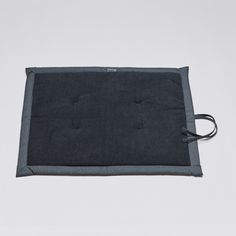 a black and grey place mat with cord