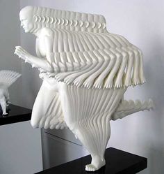 a white sculpture sitting on top of a black shelf