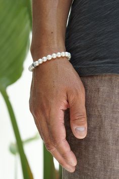 Featuring premium Freshwater Pearls, sterling silver hardware and a single Maya David silver bead, this bracelet combines classic elegance with a modern edge. A must-have in any man's jewelry collection. Sterling Silver Freshwater Pearls 7mm Thickness Push Clasp Handcrafted in LA Pair with our Men's Pearl Necklace Determining your bracelet size: Encircle your wrist with a flexible tape measure and record the measurement. Because of the larger pearl size, add 3/4 to 1 inch to your wrist measureme Classic Sterling Silver Bracelet With Beads, Elegant Everyday Sterling Silver Bracelet With Silver Beads, Minimalist White Sterling Silver Jubilee Bracelet, Classic Sterling Silver Oyster Bracelet, Luxury White Sterling Silver Adjustable Bracelet, Elegant Hand-strung Bracelets, Luxury Adjustable White Sterling Silver Bracelet, Classic Beaded Bracelets With Sterling Silver Clasp As Gift, Silver Single Strand Bracelet For Everyday