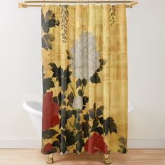 a yellow shower curtain with red and white flowers on it next to a bathtub