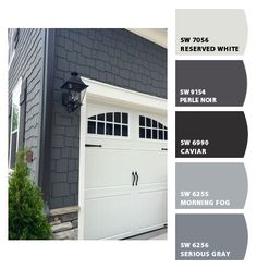 the exterior of a house with gray paint and white trim, including an overhead garage door