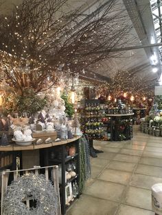 a store filled with lots of christmas decorations and lights hanging from the ceiling above it