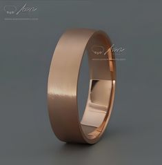 an image of a gold wedding ring on grey background