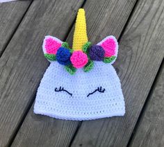 a crocheted unicorn hat on top of a wooden table