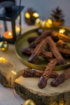 chocolate pretzels are on a plate next to christmas decorations and lights in the background