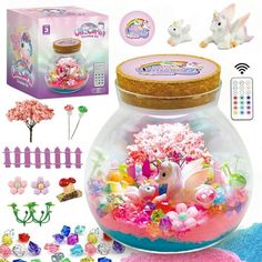 an assortment of toys and decorations in a glass bowl with pink flowers, unicorn figurines and other items