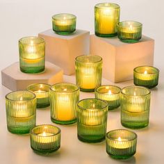 many green glass candles sitting on top of each other