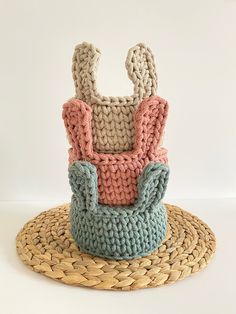 a crocheted basket sitting on top of a woven mat next to a straw hat