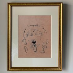 a framed drawing of a dog's face in black ink on pink paper with gold trim