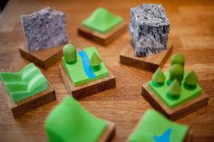 several small pieces of green plastic sitting on top of a wooden table next to each other