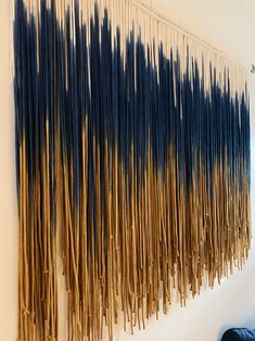 the wall is made up of sticks that have been dyed blue and gold