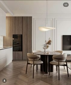 a dining room table with four chairs and a television mounted on the wall behind it