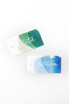 two watercolor tags with the words suitee and william written in white ink on them