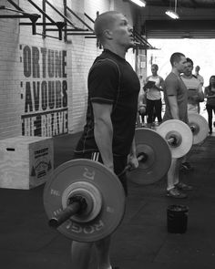 a group of people holding barbells in a gym