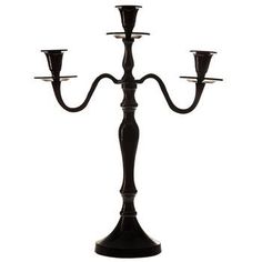 a black candelabra with three candles on it's sides and one candle in the middle