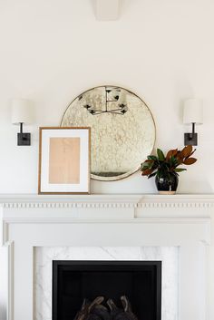 a fireplace with a mirror above it and a potted plant on the mantel