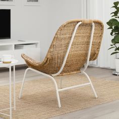 a wicker chair sitting on top of a rug in front of a tv set