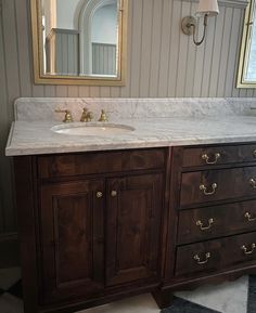 a bathroom vanity with marble top and two sinks