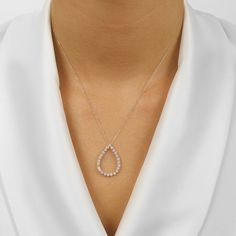 This elegant eternity pendant with its slim teardrop silhouette is decked with round brilliant cut diamonds 1/4, 1/2, or 1 CTW. Its gracefully floating effect on the collarbone is held in place by a sturdy chain. Luxurious and timeless, this diamond pendant is a must-have for any special occasion, its eye-catching fire and sparkle making it an ideal treasured gift. Visit your closest IDC location to make this extravagant diamond pendant a part of your collection—a timeless symbol of beauty and s Fine Jewelry White Gold Teardrop Diamond Necklace, Brilliant Cut Teardrop Diamond Necklace, White Gold Brilliant Cut Drop Diamond Necklace, Minimalist Teardrop Brilliant Cut Necklace, Minimalist Teardrop Necklace With Brilliant Cut, Teardrop White Gold Diamond Necklace With Brilliant Cut, Pear-shaped Diamond Drop Necklace In Diamond White, Cubic Zirconia Teardrop Diamond Necklace With Prong Setting, Teardrop Cubic Zirconia Diamond Necklace In Brilliant Cut