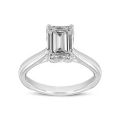 a white gold ring with an emerald cut diamond in the center, on a white background