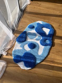 a blue and white rug sitting on top of a wooden floor next to a window