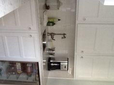 a kitchen with white cabinets and an open refrigerator freezer next to the counter top