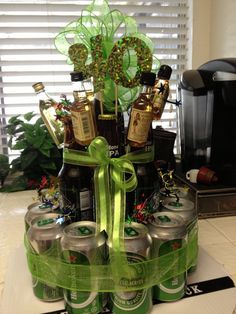 an arrangement of beer bottles in a gift box with green ribbon and bow on top