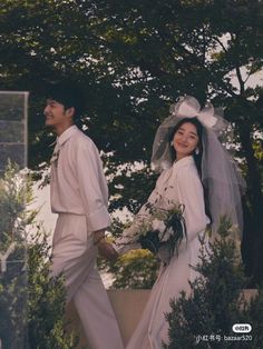 a man and woman dressed in white walking together