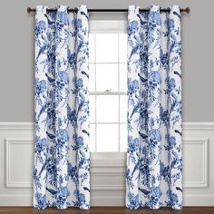 the blue and white curtains are hanging in front of a window