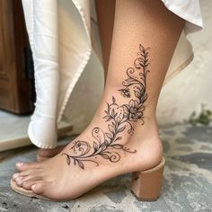 a woman's foot with a flower tattoo on her left side and the bottom part of her leg