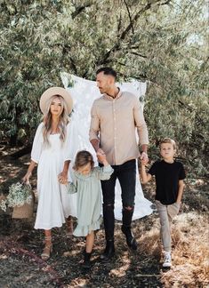 a family walking through the woods holding hands