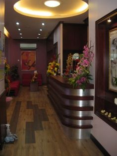 a long hallway with flowers and pictures on the wall