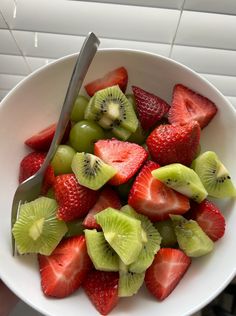 a white bowl filled with sliced kiwis and strawberries