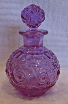 a purple glass vase sitting on top of a table