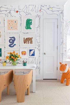 a child's room with wallpaper and artwork on the walls, including an orange toy