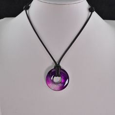 a purple and black necklace on a mannequin's neck with a circle pendant