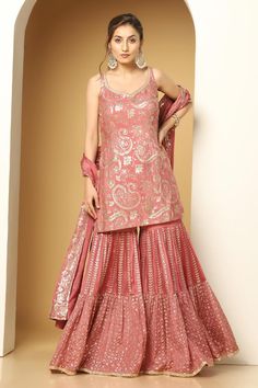 Onion pink sleeveless padded short kurta in chinon chiffon base with all over sequin paisley fleur embroidery and paan neckline. Paired with a vine and floral jaal embellished sharara and embroidered border dupatta. - Aza Fashions Semi-stitched Sleeveless Sharara For Reception, Sleeveless Sharara For Eid Reception, Anarkali Style Sleeveless Sharara In Georgette, Sleeveless Anarkali Sharara In Georgette, Sleeveless Sharara With Zari Work For Reception, Festive Sleeveless Lehenga With Chikankari Embroidery, Sleeveless Georgette Sharara For Festive Occasions, Sleeveless Palazzo Set With Zari Work, Elegant Sleeveless Sharara For Diwali